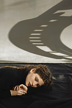 Shadow on wall over pensive Caucasian woman