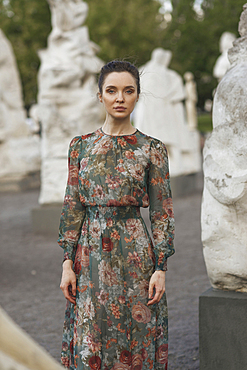 Portrait of confident Caucasian woman standing near statues