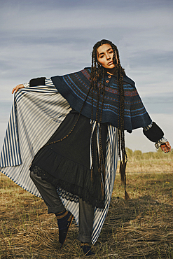 Caucasian woman wearing traditional clothing dancing in field