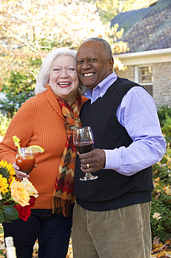 Couple hugging outdoors and enjoying wine and cocktail