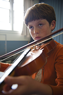 Close up of Caucasian boy practicing violin