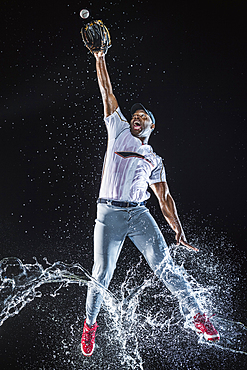 Water splashing on legs Black baseball player catching baseball