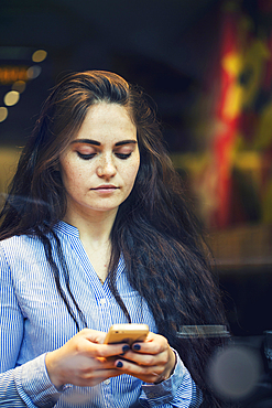 Serious Caucasian woman texting on cell phone