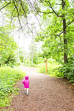 Caucasian girl walking on path in forest