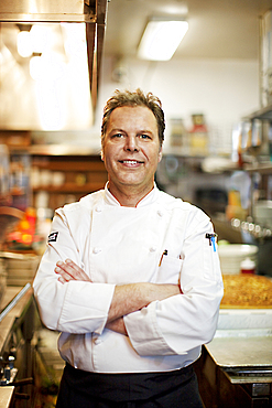 Confident Caucasian chef standing in commercial kitchen