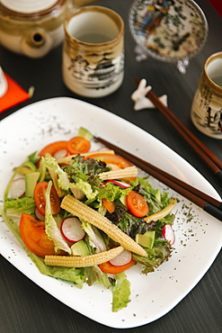 Chopsticks on plate of salad