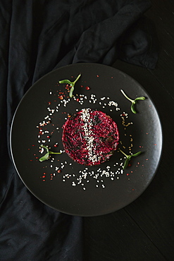 Sesame seeds and garnish on red food on plate