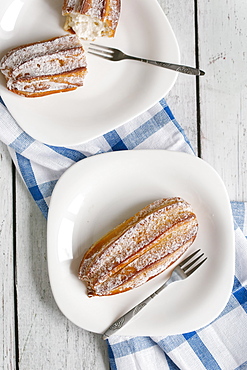 Pastry with powdered sugar on plate with fork