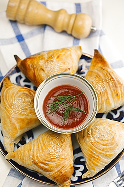 Pastry with sesame seeds on plate with sauce