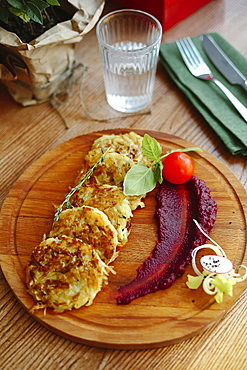 Hash browns and sauce on wooden tray