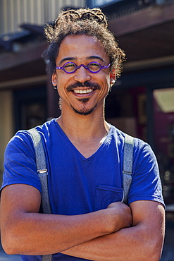 Smiling mixed race man wearing suspenders