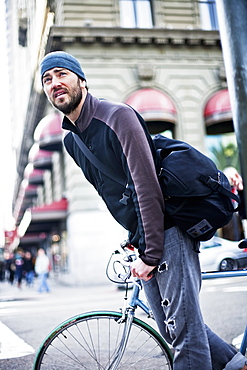 Caucasian man riding bicycle in city