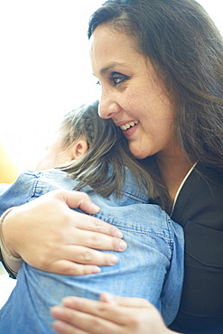 Hispanic mother hugging daughter