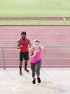 Trainer timing woman running on bleachers