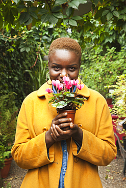 Portrait of smiling Black woman smelling flowers