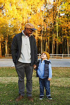 Father and son holding hands in park