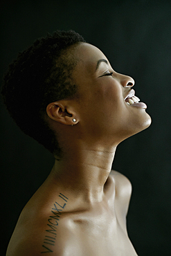 Profile of Black woman laughing with eyes closed