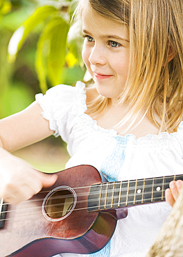 Caucasian girl playing ukulele