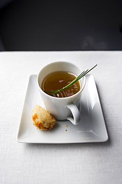 Spring of herb in cup of broth with bread