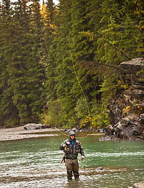 Caucasian man casting in river