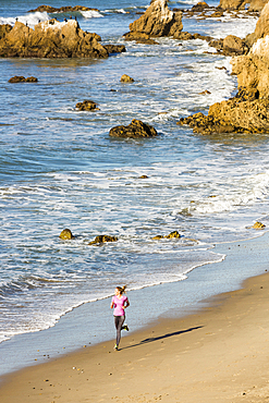 Caucasian woman running on beach