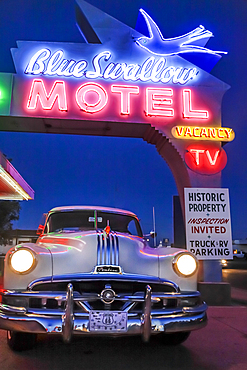 Old-fashioned car in motel parking lot at night