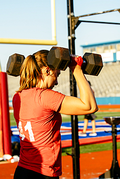 Caucasian woman lifting weights outdoors