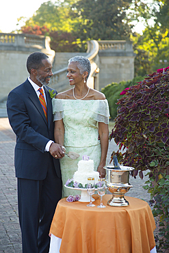 Black couple cutting wedding cake