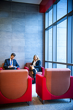 Businessman and businesswoman sitting in office lounge