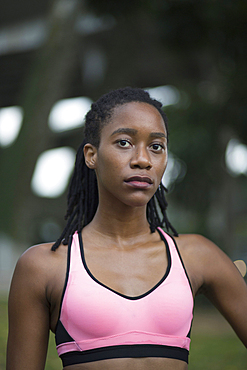 Serious Mixed Race woman wearing pink sports-bra