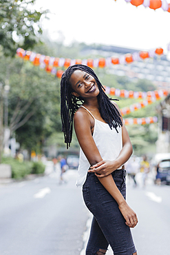 Portrait of smiling Mixed Race woman standing in street