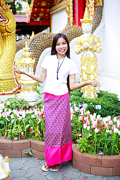 Smiling Asian woman standing in ornate garden