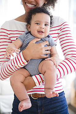 Smiling mother holding baby son