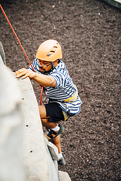 Mixed Race man climbing rock climbing wall