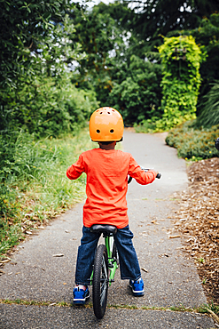 Black boy on bicycle wearing helmet