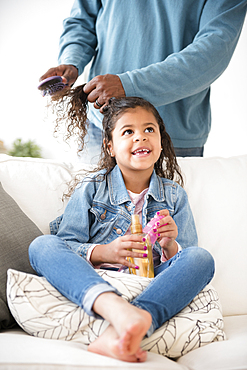 Father brushing hair of daughter