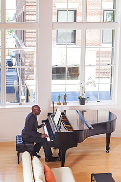 Man playing piano near window