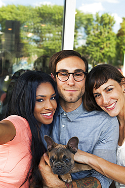 Friends posing with dog for selfie