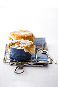 Seafood pot pies and forks on rack