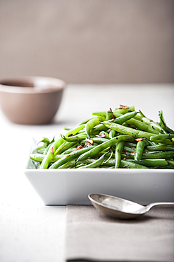 Pile of roasted green beans with spoon