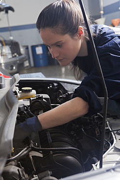 Hispanic mechanic repairing car engine