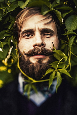 Vine curling around face of man with beard