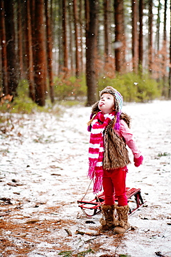 Caucasian girl catching snow on tongue