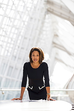 Black businesswoman leaning over paperwork conference room