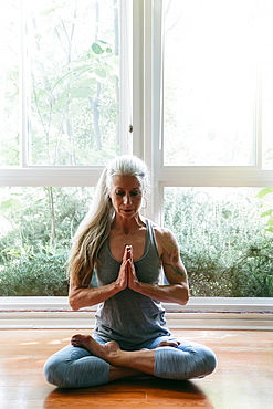 Caucasian woman meditating on floor