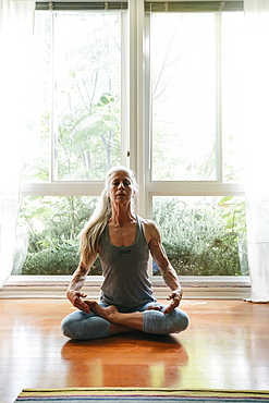 Caucasian woman meditating on floor