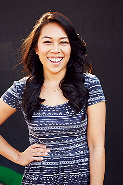 Laughing Pacific Islander woman standing with hand on hip