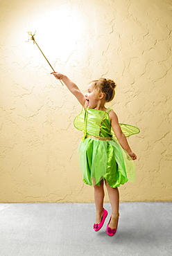 Girl wearing green fairy costume with wand