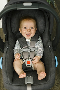 Portrait of smiling boy (2-3) in car seat