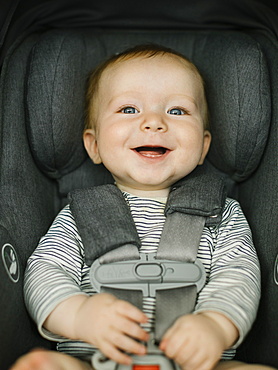 Portrait of smiling boy (2-3) in car seat